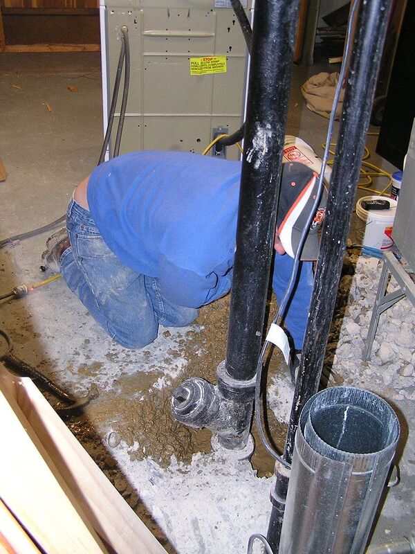 Technicien utilisant un détecteur de gaz traceur pour localiser une fuite